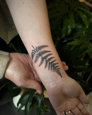 Cute fern scar cover up tattoo on arm just above the wrist, done by Symone from Ashton Ink Tattoo Studio - tattoo shops tameside